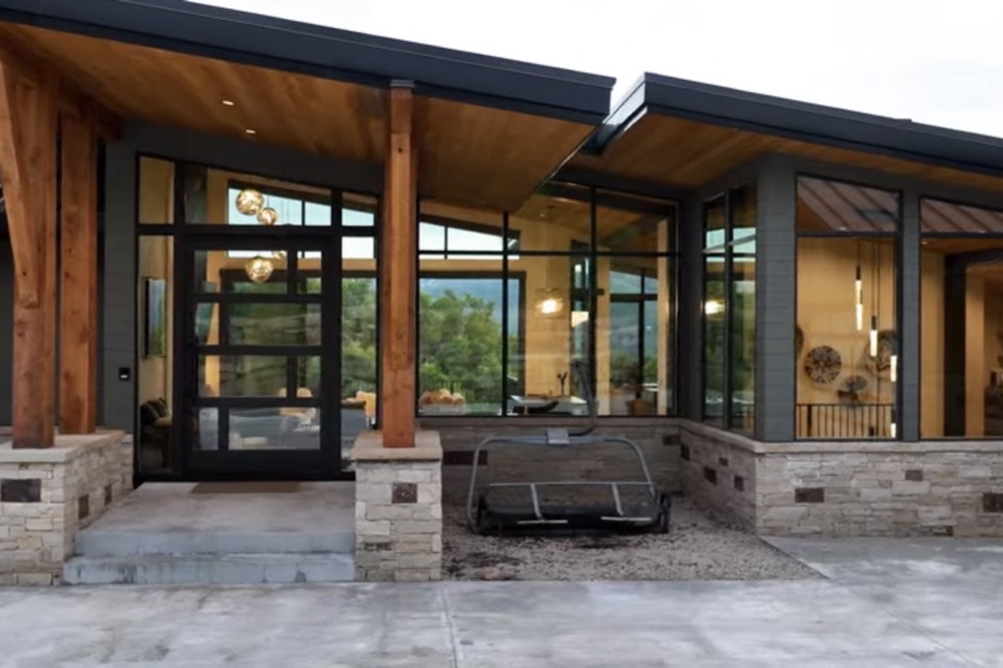 The glazed entry, timber columns and stone piers at dusk