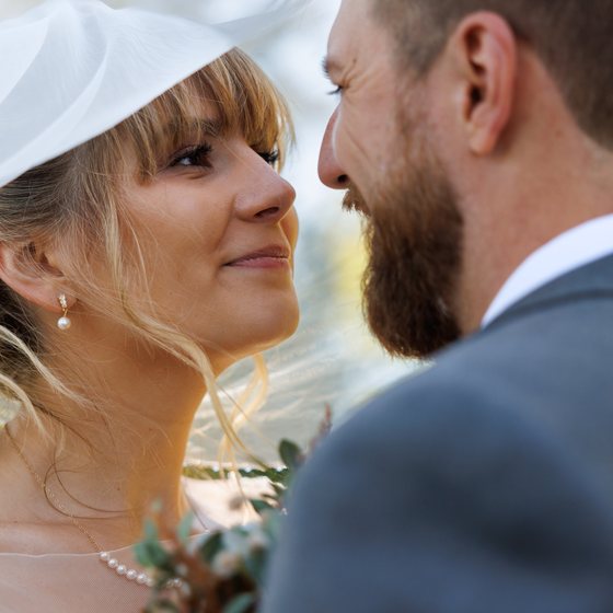 A bride and groom looking at each other beneath her veil