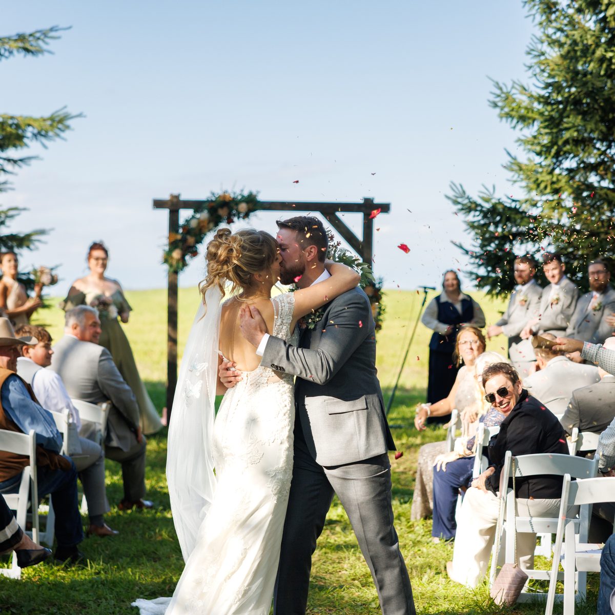A couple kissing at the altar as their guests celebrate