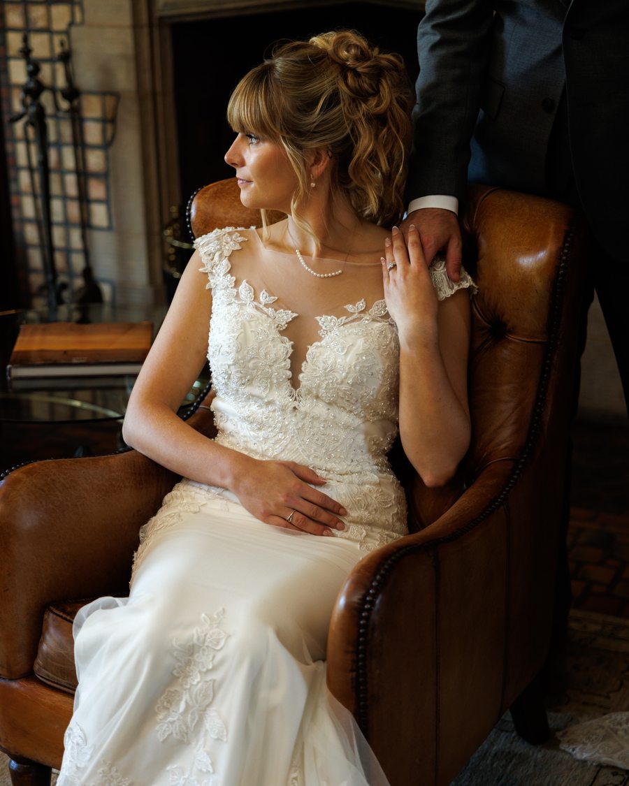 A bride seated in a leather armchair in warm interior light